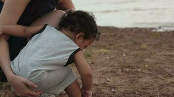 Family happy, Mother and baby doing outdoor activities on the shore of a lake at sunset in summer. video