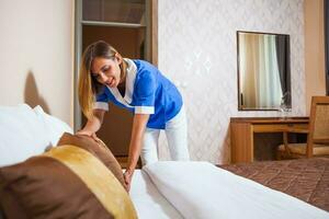 A maid working in a hotel room photo