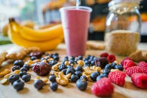 Healthy protein shake on table with fruits and vegetables ingredients around photo