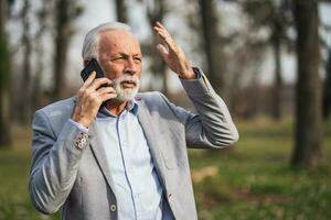 A senior businessman having a phone conversation photo