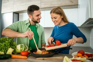 un joven Pareja Cocinando juntos foto