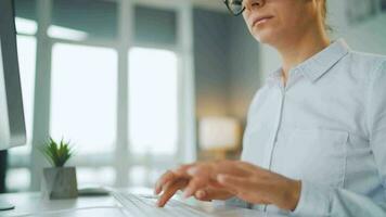 Woman with glasses typing on a computer keyboard. Concept of remote work video