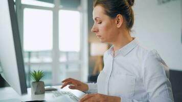 mujer con lentes mecanografía en un computadora teclado. concepto de remoto trabajo video