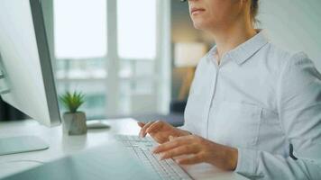 mulher com óculos digitando em uma computador teclado. conceito do controlo remoto trabalhos video