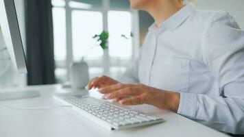 mujer con lentes mecanografía en un computadora teclado. concepto de remoto trabajo video