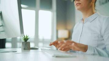 femme avec des lunettes dactylographie sur une ordinateur clavier. concept de éloigné travail video