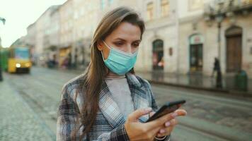 Pandemic protection of the Covid-19 coronavirus. Portrait of a woman in a coat, glasses and a protective medical mask. Glasses fog up from breath. Virus protection video