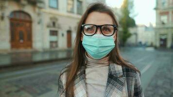 pandémie protection de le covid-19 corona virus. portrait de une femme dans une manteau, des lunettes et une protecteur médical masque. des lunettes brouillard en haut de haleine. virus protection video