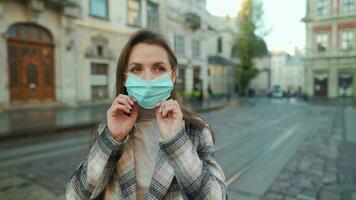 Pandemic protection of the Covid-19 coronavirus. Portrait of a woman in a coat, glasses and a protective medical mask. Glasses fog up from breath. Virus protection video