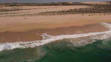 Flying over the beach. Giant waves foaming and splashing in the ocean from a top angle video