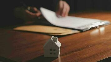 Immobilienmakler-Agent präsentiert und berät den Kunden bei der Entscheidungsfindung, unterzeichnet den Versicherungsvertrag, das Hausmodell, das Hypothekendarlehensangebot für und die Hausversicherung. video