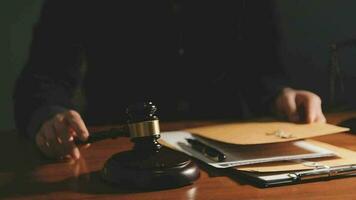 Justice and law concept.Male judge in a courtroom with the gavel, working with, computer and docking keyboard, eyeglasses, on table in morning light video