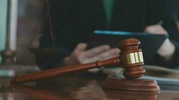 Justice and law concept.Male judge in a courtroom with the gavel, working with, computer and docking keyboard, eyeglasses, on table in morning light video