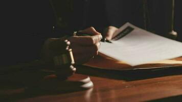 Justice and law concept.Male judge in a courtroom with the gavel, working with, computer and docking keyboard, eyeglasses, on table in morning light video