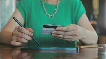 mani Tenere plastica credito carta e utilizzando il computer portatile. in linea shopping concetto. tonica immagine video