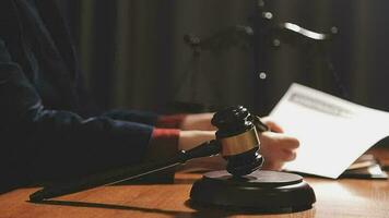 Justice and law concept.Male judge in a courtroom with the gavel, working with, computer and docking keyboard, eyeglasses, on table in morning light video