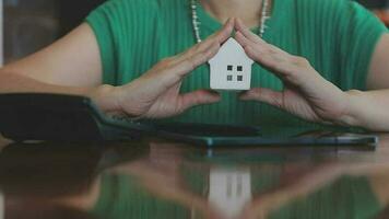 fastighetsmäklare presenterar och rådgör med kund till beslutsfattande teckna försäkringsformulär avtal, hemmodell, gällande bolåneerbjudande för och villaförsäkring. video