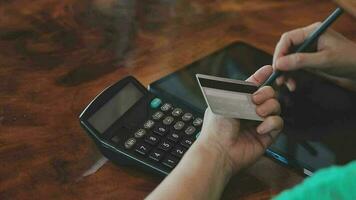 en línea pago, hombre manos participación un crédito tarjeta y utilizando inteligente teléfono para en línea compras video