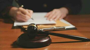 Justice and law concept.Male judge in a courtroom with the gavel, working with, computer and docking keyboard, eyeglasses, on table in morning light video