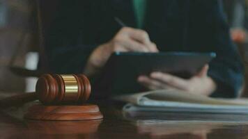 Justice and law concept.Male judge in a courtroom with the gavel, working with, computer and docking keyboard, eyeglasses, on table in morning light video