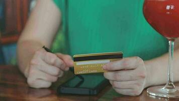 Hands holding plastic credit card and using laptop. Online shopping concept. Toned picture video