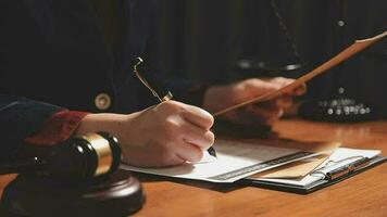 Justice and law concept.Male judge in a courtroom with the gavel, working with, computer and docking keyboard, eyeglasses, on table in morning light video