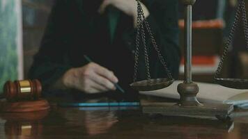 Justice and law concept.Male judge in a courtroom with the gavel, working with, computer and docking keyboard, eyeglasses, on table in morning light video