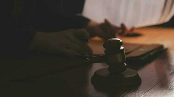 Justice and law concept.Male judge in a courtroom with the gavel, working with, computer and docking keyboard, eyeglasses, on table in morning light video