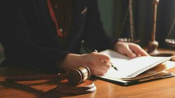 Justice and law concept.Male judge in a courtroom with the gavel, working with, computer and docking keyboard, eyeglasses, on table in morning light video