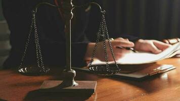 Justice and law concept.Male judge in a courtroom with the gavel, working with, computer and docking keyboard, eyeglasses, on table in morning light video