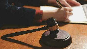 Justice and law concept.Male judge in a courtroom with the gavel, working with, computer and docking keyboard, eyeglasses, on table in morning light video