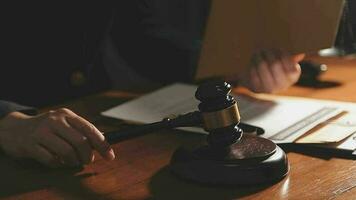 Justice and law concept.Male judge in a courtroom with the gavel, working with, computer and docking keyboard, eyeglasses, on table in morning light video