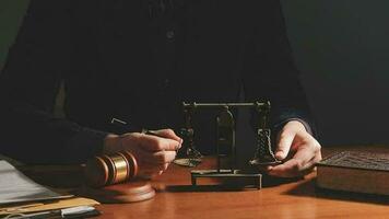 Justice and law concept.Male judge in a courtroom with the gavel, working with, computer and docking keyboard, eyeglasses, on table in morning light video