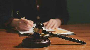 Justice and law concept.Male judge in a courtroom with the gavel, working with, computer and docking keyboard, eyeglasses, on table in morning light video