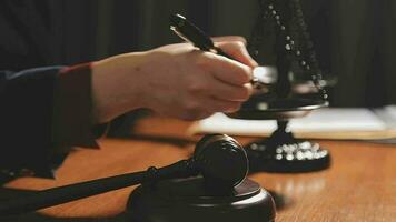 Justice and law concept.Male judge in a courtroom with the gavel, working with, computer and docking keyboard, eyeglasses, on table in morning light video