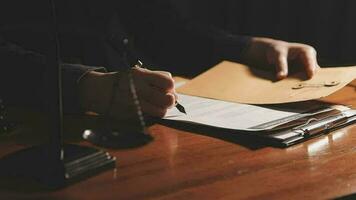 Justice and law concept.Male judge in a courtroom with the gavel, working with, computer and docking keyboard, eyeglasses, on table in morning light video