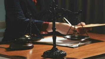 Justice and law concept.Male judge in a courtroom with the gavel, working with, computer and docking keyboard, eyeglasses, on table in morning light video