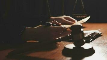 Justice and law concept.Male judge in a courtroom with the gavel, working with, computer and docking keyboard, eyeglasses, on table in morning light video