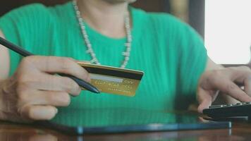 conectados pagamento, homem mãos segurando uma crédito cartão e usando inteligente telefone para conectados compras video