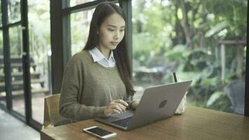 Office woman sitting at coffee shop with notebook and taking notes in notebook video