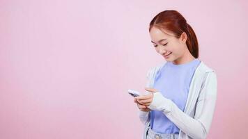 asiatico donna utilizzando Telefono nel bene umore sorridente, condimento comodamente e chat su sociale media. video