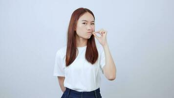 schließen oben jung asiatisch Frau drückt ihr Lippen zeigen Verbot, tun nicht sprechen, behalten ruhig, ausblenden Geheimnisse, Stehen Über Weiß Hintergrund. video