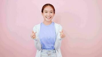 asiático niña demostración corazón amor gesto y sonriente blanco dientes Rápido cuidado y simpatía video