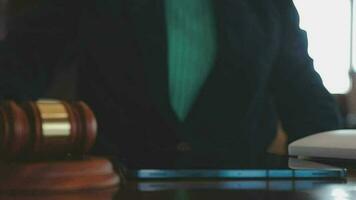 concept de justice et de droit. juge masculin dans une salle d'audience avec le marteau, travaillant avec, clavier d'ordinateur et d'accueil, lunettes, sur table à la lumière du matin video