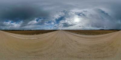 spherical 360 hdri panorama on gravel road with clouds on overcast sky in equirectangular seamless projection, use as sky replacement in drone panoramas, game development as sky dome or VR content photo