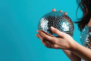 Shiny disco ball in a woman hand isolated on a bright blue background. nightlife, and celebration inspired idea. illustration photo