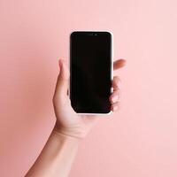Mobile phone with empty white screen in hand on pink background photo
