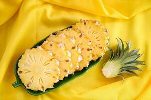 pineapple slice on plate for food fruit ripe pineapple on yellow background, fresh pineapple tropical fruits summer - top view photo