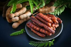 Tamarind sweet for food fruit ripe tamarinds on dark plate background, Tamarind peel tropical fruits summer photo