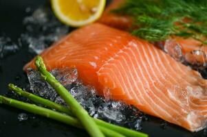 salmon fillet with lemon asparagus herb and spices, fresh raw salmon fish on ice for cooking food seafood salmon fish photo
